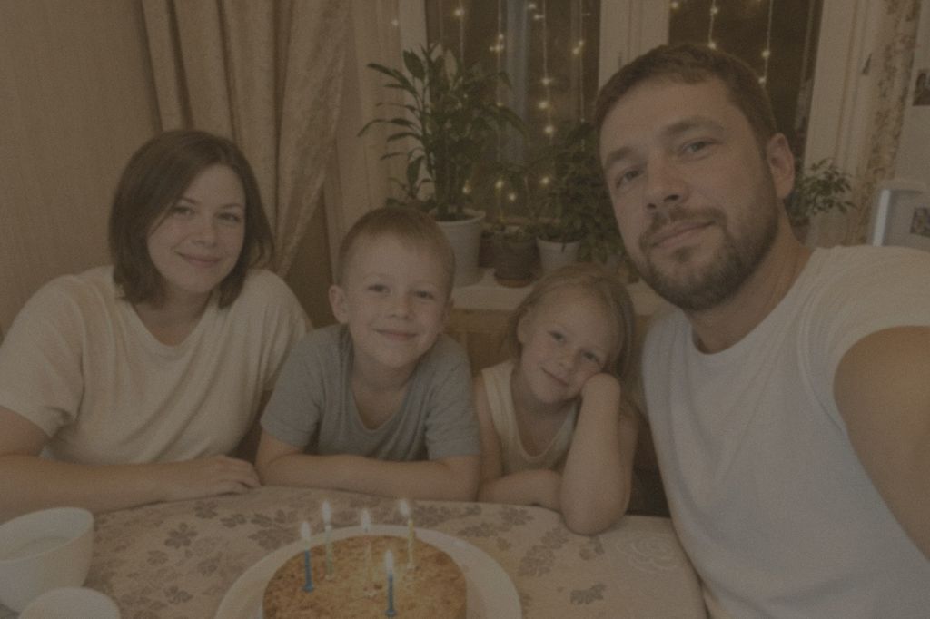Тёмная смазанная фотография семьи за праздничным столом, снятая на телефон